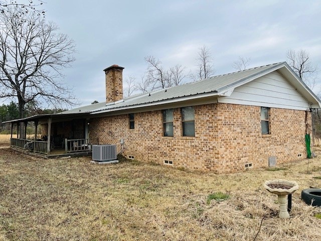 back of house with a sunroom, a yard, and central AC unit