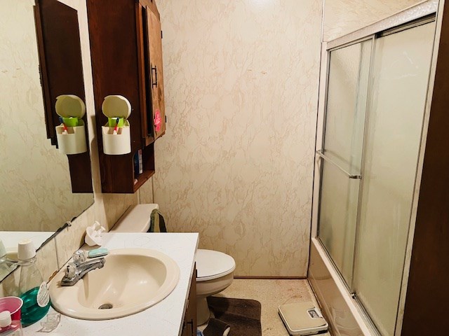 full bathroom featuring vanity, toilet, and combined bath / shower with glass door