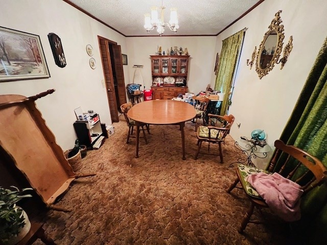 carpeted dining area with ornamental molding, a chandelier, and a textured ceiling