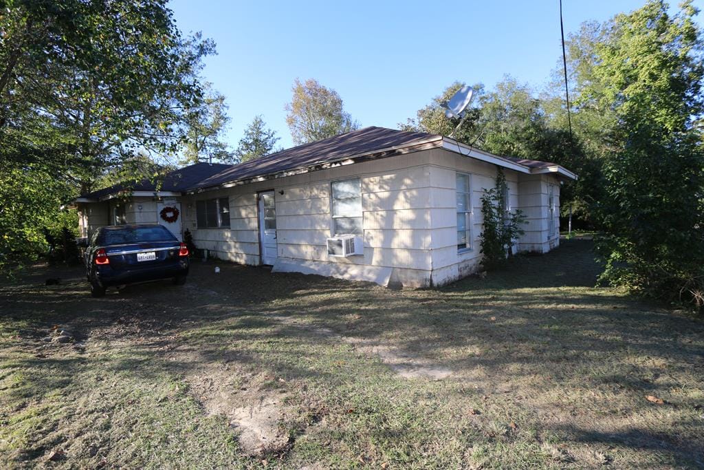 view of side of home with a yard and cooling unit