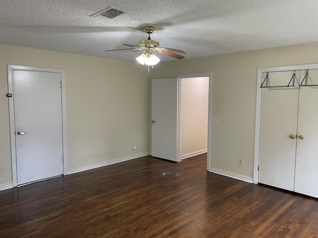 unfurnished bedroom with ceiling fan, dark hardwood / wood-style flooring, and a textured ceiling