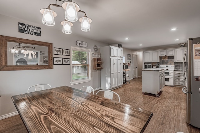 dining space with dark wood-type flooring and a notable chandelier