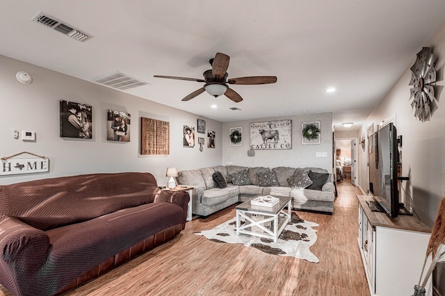 living room with light hardwood / wood-style floors and ceiling fan