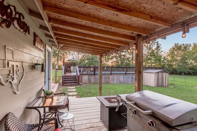 wooden terrace with a lawn, a grill, and a storage shed