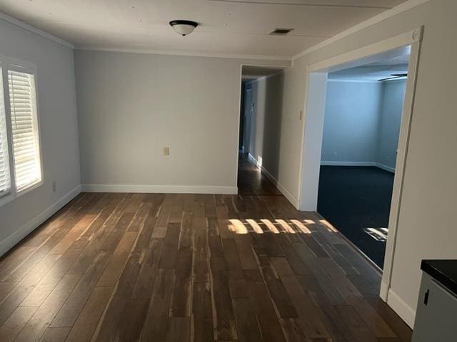 empty room featuring crown molding and dark hardwood / wood-style floors