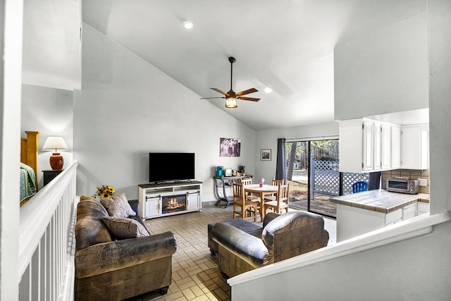 living room with ceiling fan and high vaulted ceiling