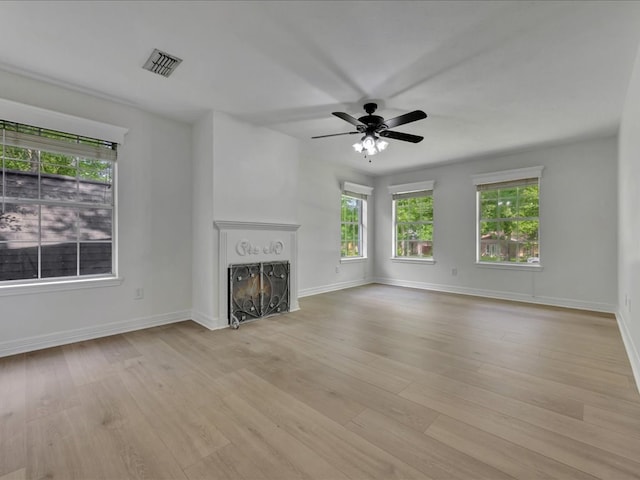 107 Bending Oak Dr, Lufkin, TX 75904 - unfurnished living room featuring healthy amount of natural light, a lit fireplace, and light wood-style floors