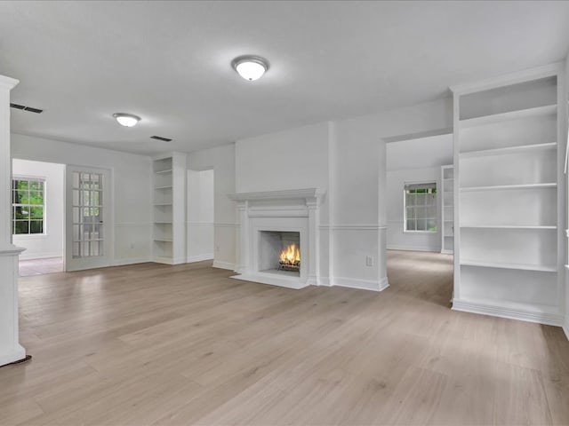 107 Bending Oak Dr, Lufkin, TX 75904 - unfurnished living room featuring light wood-style floors, a fireplace with flush hearth, and built in shelves