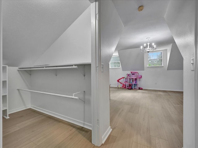 107 Bending Oak Dr, Lufkin, TX 75904 - bonus room featuring wood finished floors, lofted ceiling, and a chandelier