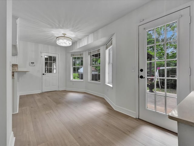 107 Bending Oak Dr, Lufkin, TX 75904 - unfurnished dining area with a chandelier, light wood-style flooring, and healthy amount of natural light