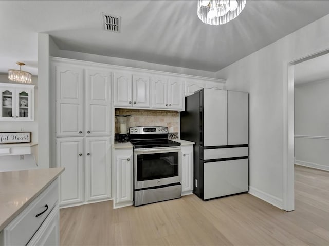 107 Bending Oak Dr, Lufkin, TX 75904 - kitchen with electric stove, freestanding refrigerator, a chandelier, white cabinets, and light wood finished floors