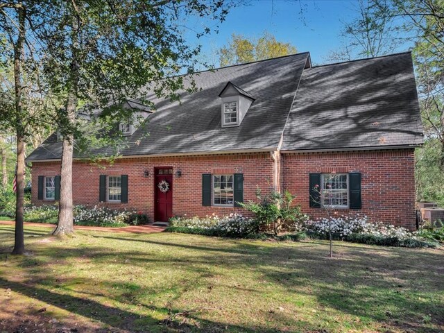 2211 Copeland St, Lufkin, TX 75904 - cape cod-style house featuring central air condition unit, a front yard, and brick siding