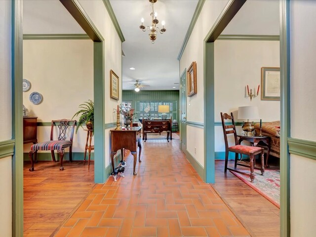 2211 Copeland St, Lufkin, TX 75904 - corridor featuring baseboards, ornamental molding, brick floor, and a notable chandelier