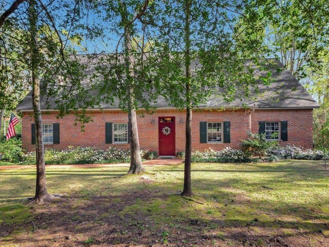 2211 Copeland St, Lufkin, TX 75904 - view of front of house with brick siding, a shingled roof, and a front lawn