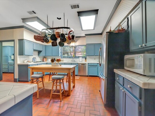 2211 Copeland St, Lufkin, TX 75904 - kitchen featuring wallpapered walls, brick floor, visible vents, dishwasher, and white microwave