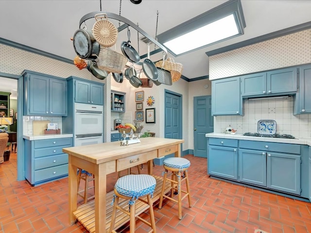 2211 Copeland St, Lufkin, TX 75904 - kitchen with wallpapered walls and blue cabinetry