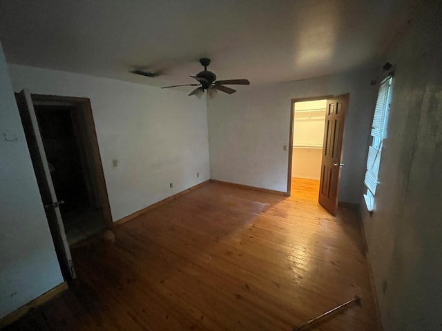 empty room with ceiling fan and light hardwood / wood-style floors