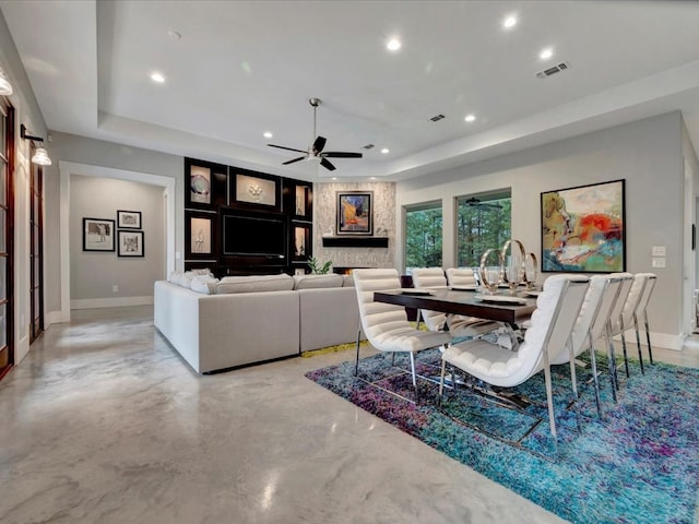 living room with ceiling fan and a tray ceiling