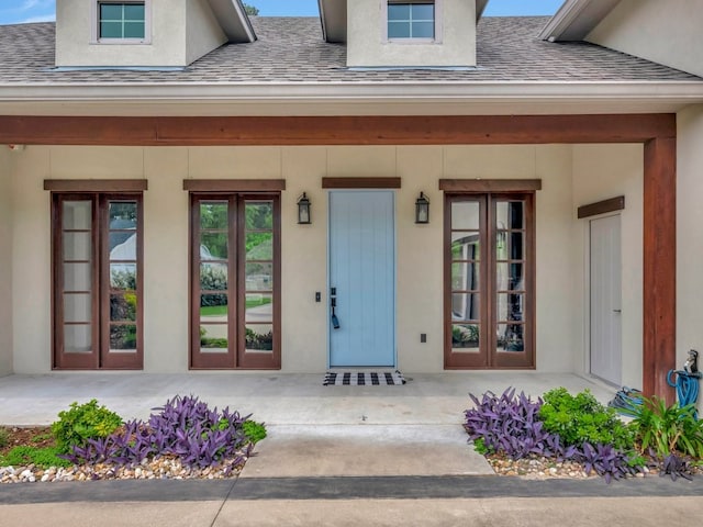 210 Mission Hills Dr, Lufkin, TX 75901 - doorway to property featuring stucco siding, a porch, a shingled roof, and french doors