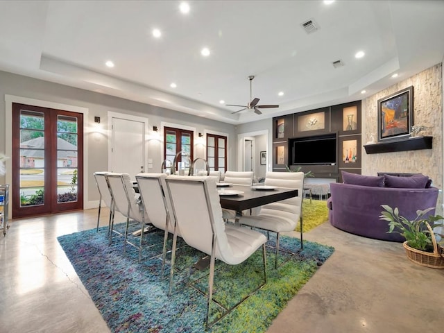 dining space with french doors, ceiling fan, and a raised ceiling