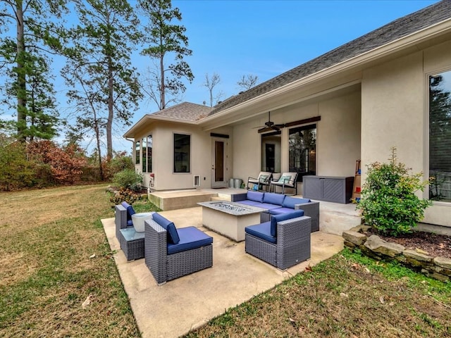 view of patio with ceiling fan and an outdoor living space with a fire pit