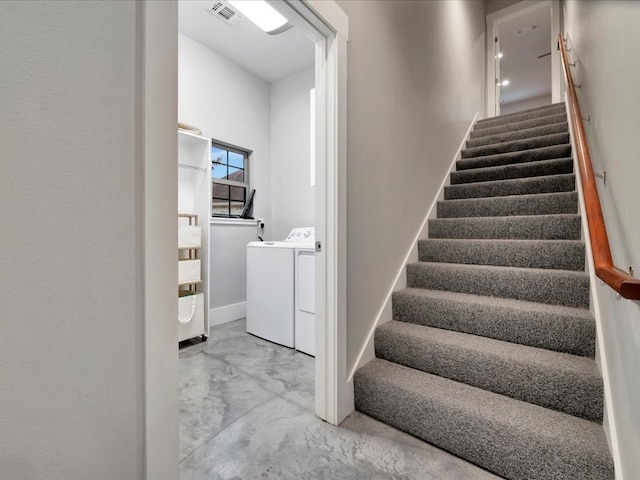 stairs featuring concrete floors and washing machine and clothes dryer