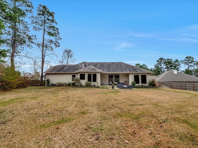 back of property with a patio area and a yard