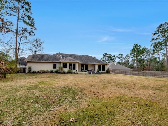 rear view of house featuring a lawn