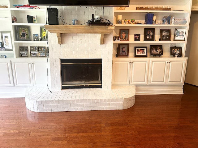 details featuring hardwood / wood-style floors and a brick fireplace