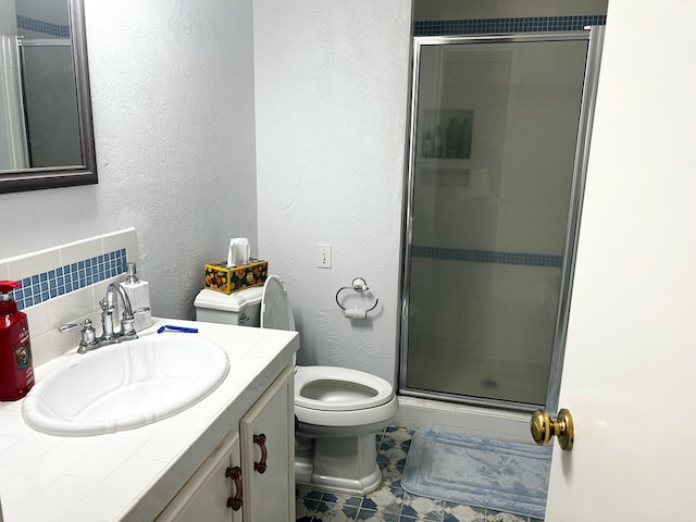 bathroom with tile patterned flooring, backsplash, toilet, vanity, and a shower with shower door