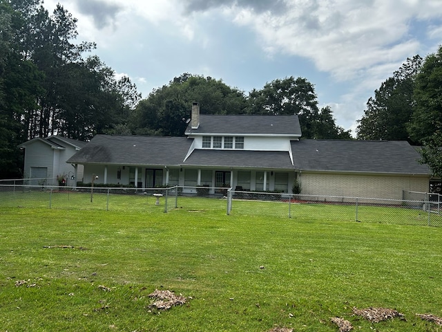 rear view of house featuring a lawn