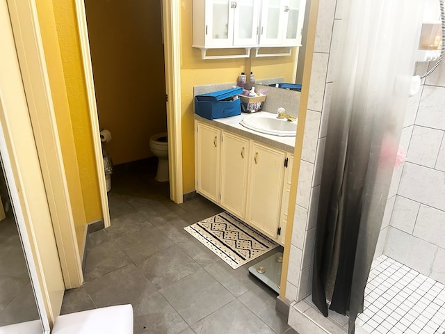 bathroom featuring tile patterned floors, vanity, toilet, and walk in shower