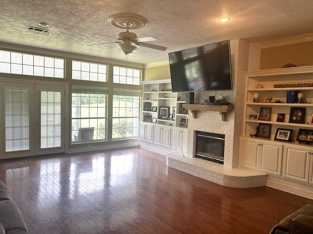 unfurnished living room with a fireplace, wood-type flooring, a textured ceiling, and ornamental molding