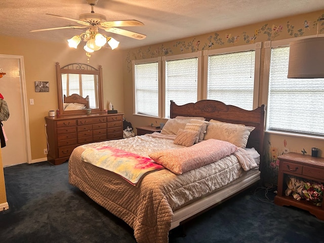 bedroom featuring a textured ceiling, dark carpet, and ceiling fan