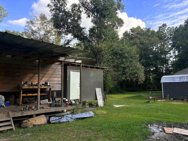 view of yard featuring a pergola, a deck, and a storage unit