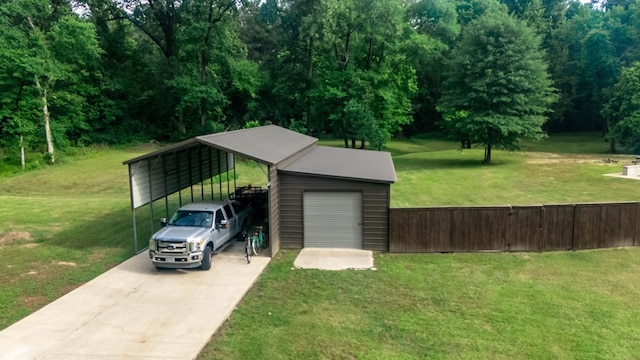 garage featuring fence and concrete driveway