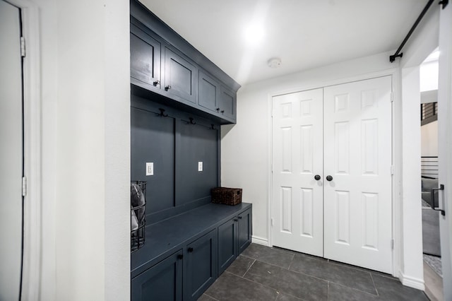mudroom with dark tile patterned floors