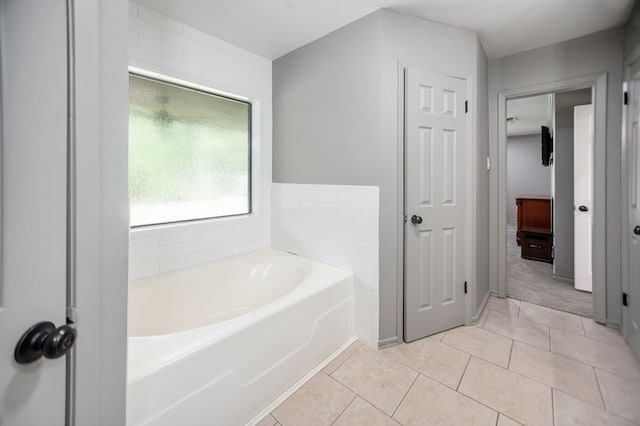 bathroom with tile patterned flooring and a bath