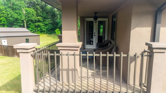 exterior space with a gate, stucco siding, a yard, and fence