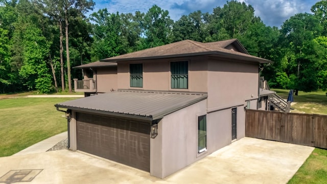 view of front of home featuring a front lawn, fence, a balcony, stucco siding, and metal roof