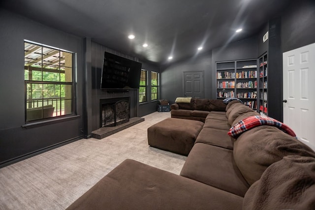 carpeted living area with recessed lighting, built in shelves, vaulted ceiling, and a fireplace