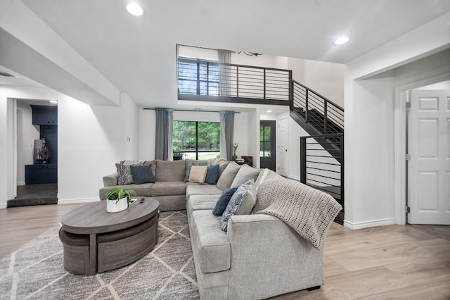 living area with recessed lighting, baseboards, and light wood-style flooring