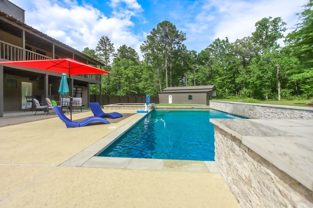 view of swimming pool featuring a patio area, a hot tub, fence, a fenced in pool, and an outdoor structure