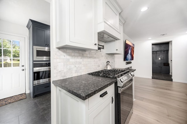 kitchen featuring backsplash, baseboards, white cabinets, stainless steel appliances, and recessed lighting