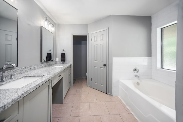 full bathroom featuring a sink, tile patterned flooring, a garden tub, and double vanity
