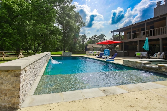 view of pool with a patio and a pool with connected hot tub
