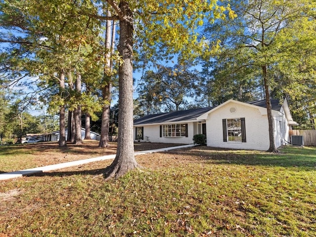 ranch-style house featuring a front lawn and cooling unit