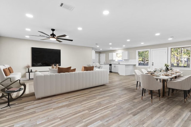 living room with ceiling fan and light wood-type flooring