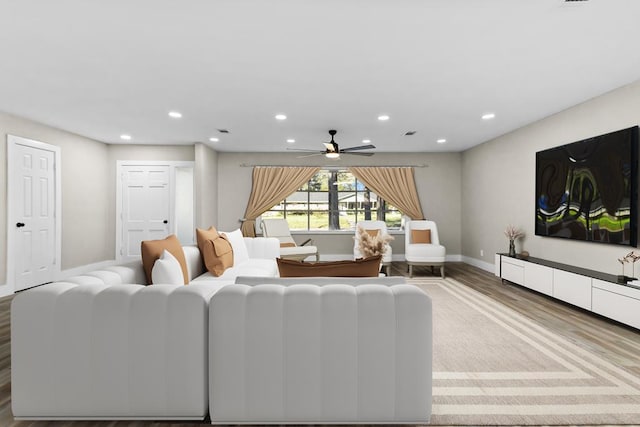 living room with ceiling fan and light hardwood / wood-style flooring