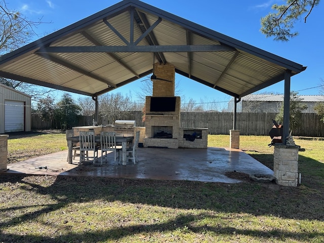 view of patio / terrace featuring fence, an outdoor stone fireplace, grilling area, and a gazebo